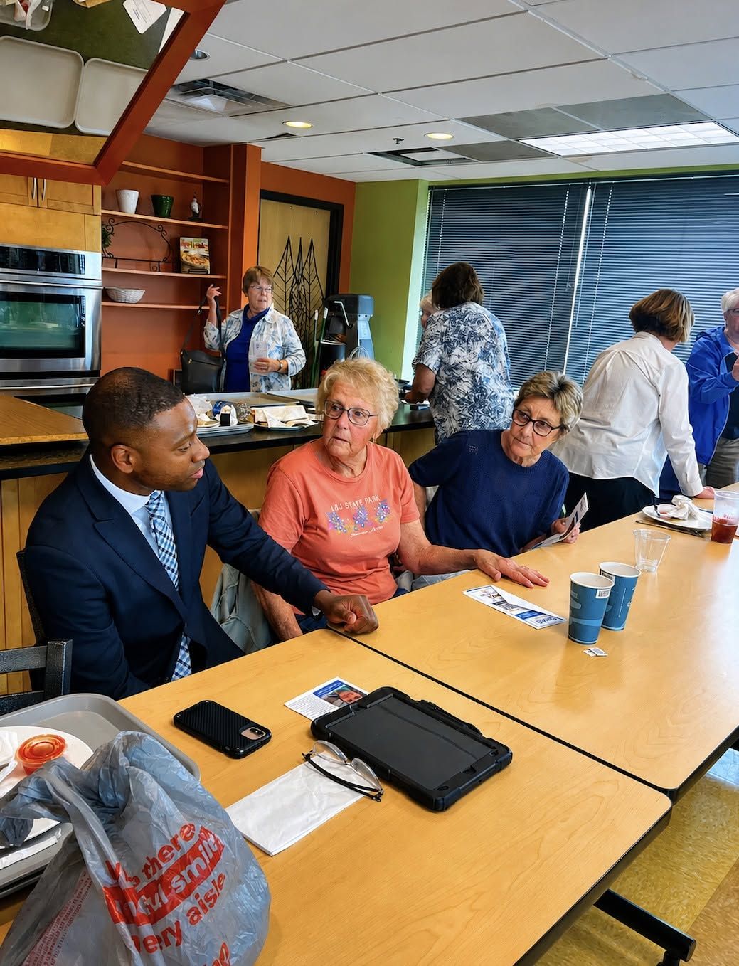 Terrence Davis sitting at a table talking with older voters
